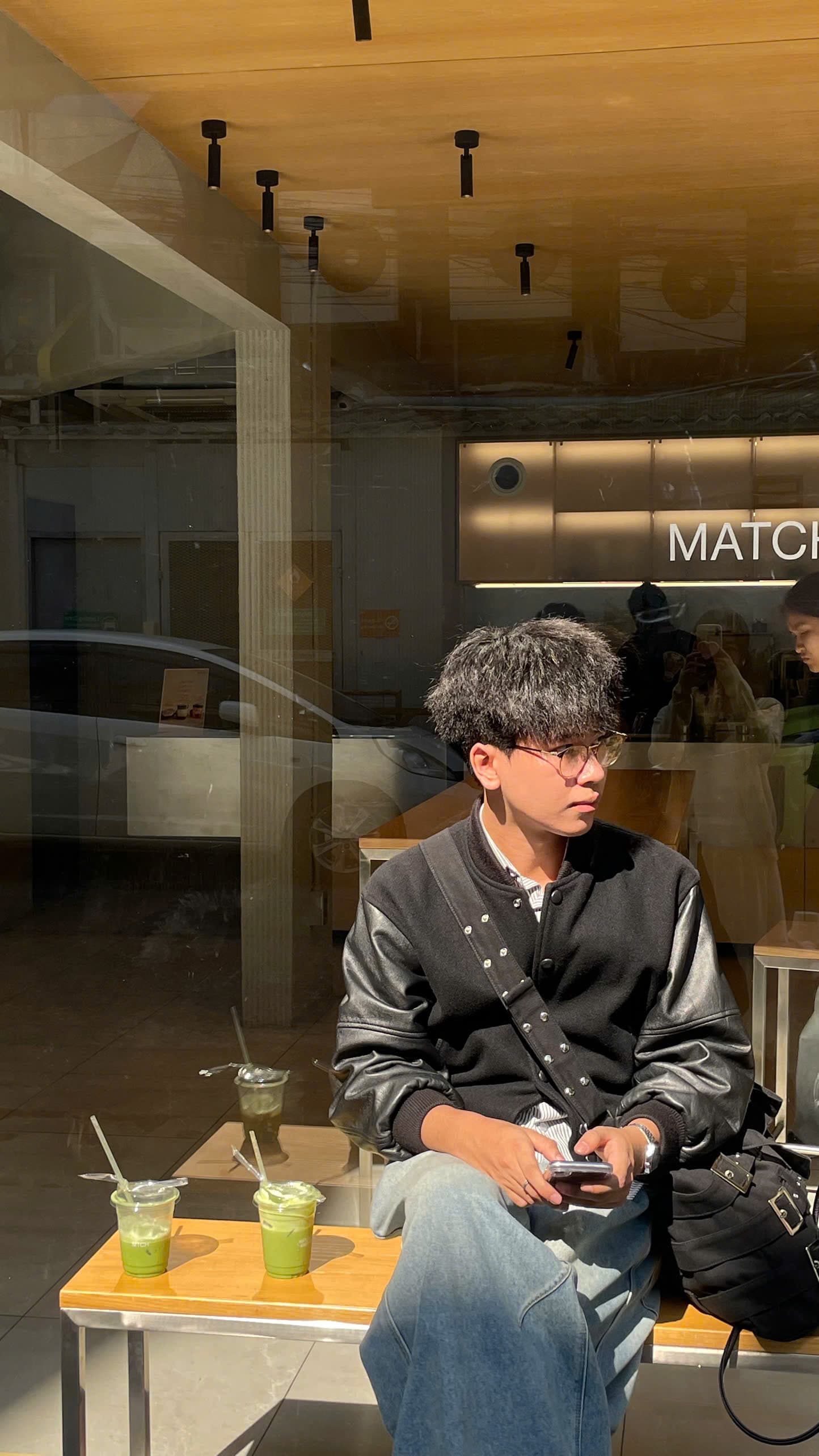 Duc Huynh sitting by a cafe window